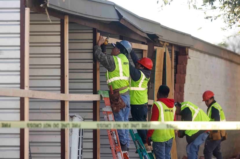 A crew works to board up a damaged opening at Extra Space Storage in Grapevine on Wednesday.
