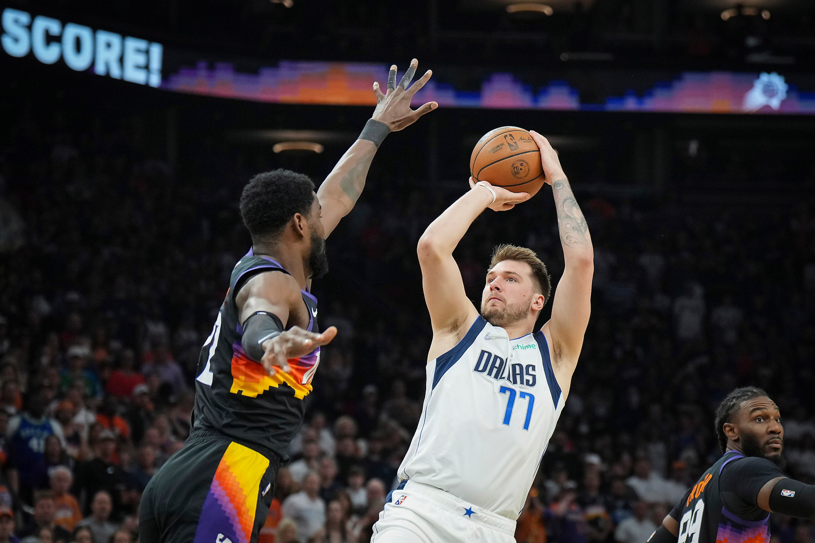 Dallas Mavericks guard Luka Doncic (77) shoots a 3-pointer over Phoenix Suns center Deandre...