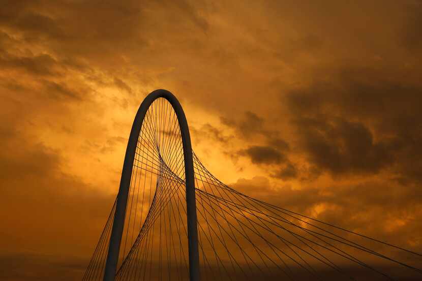 Theseting sun illuminates the storms clouds moving east from the Margaret Hunt Hill Bridge...