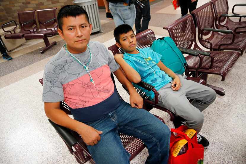 Central American immigrants Waldemar Cuztical and his son Walter Humberto, 12,  waited for...