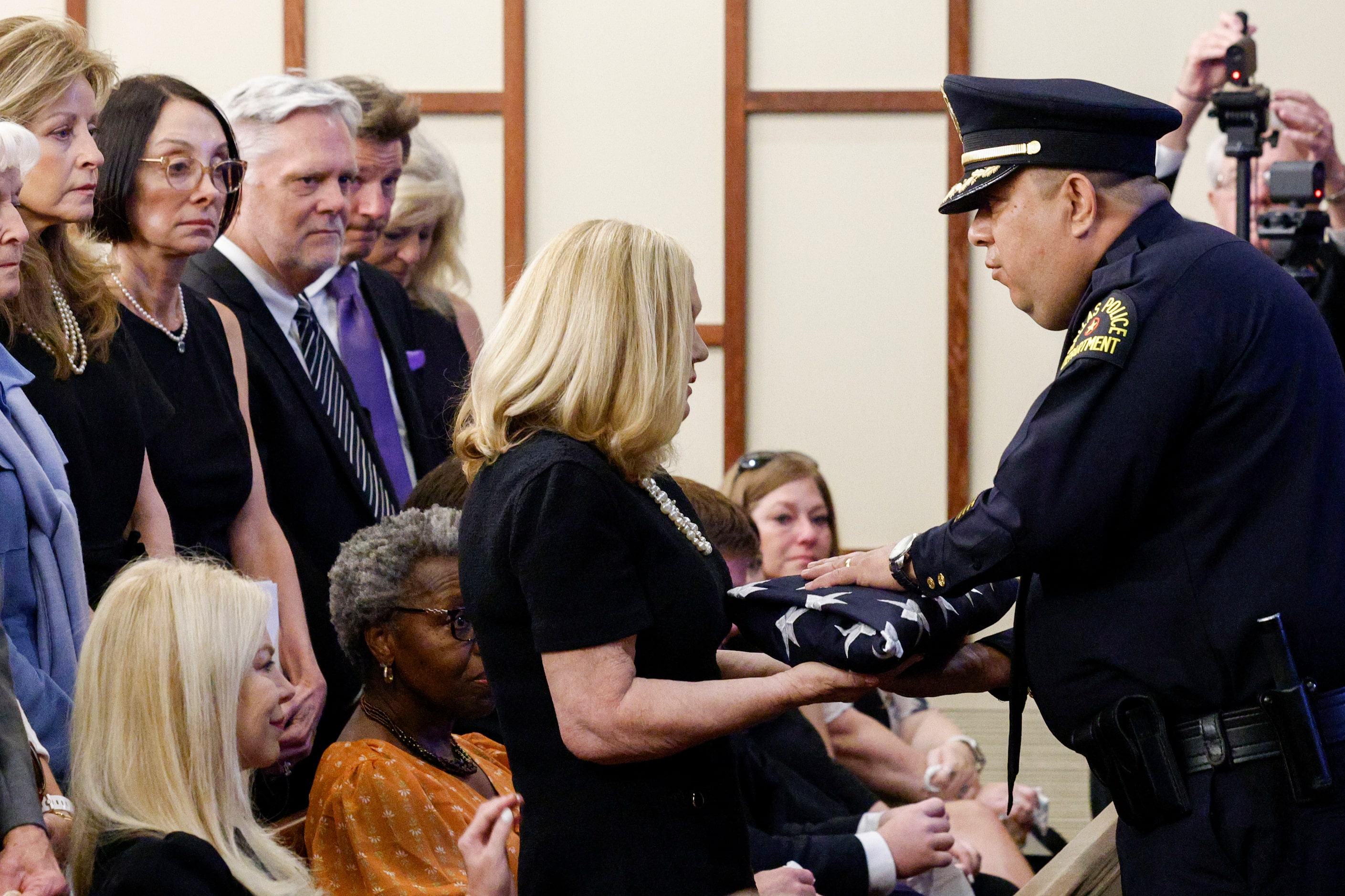 Dallas police Executive Assistant Chief Albert Martinez presents a flag to David Kunkle’s...