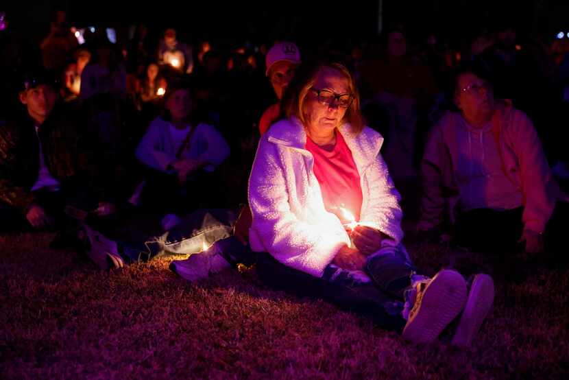 Carol Warren of Boyd gets emotional while holding a candle during a memorial service for...