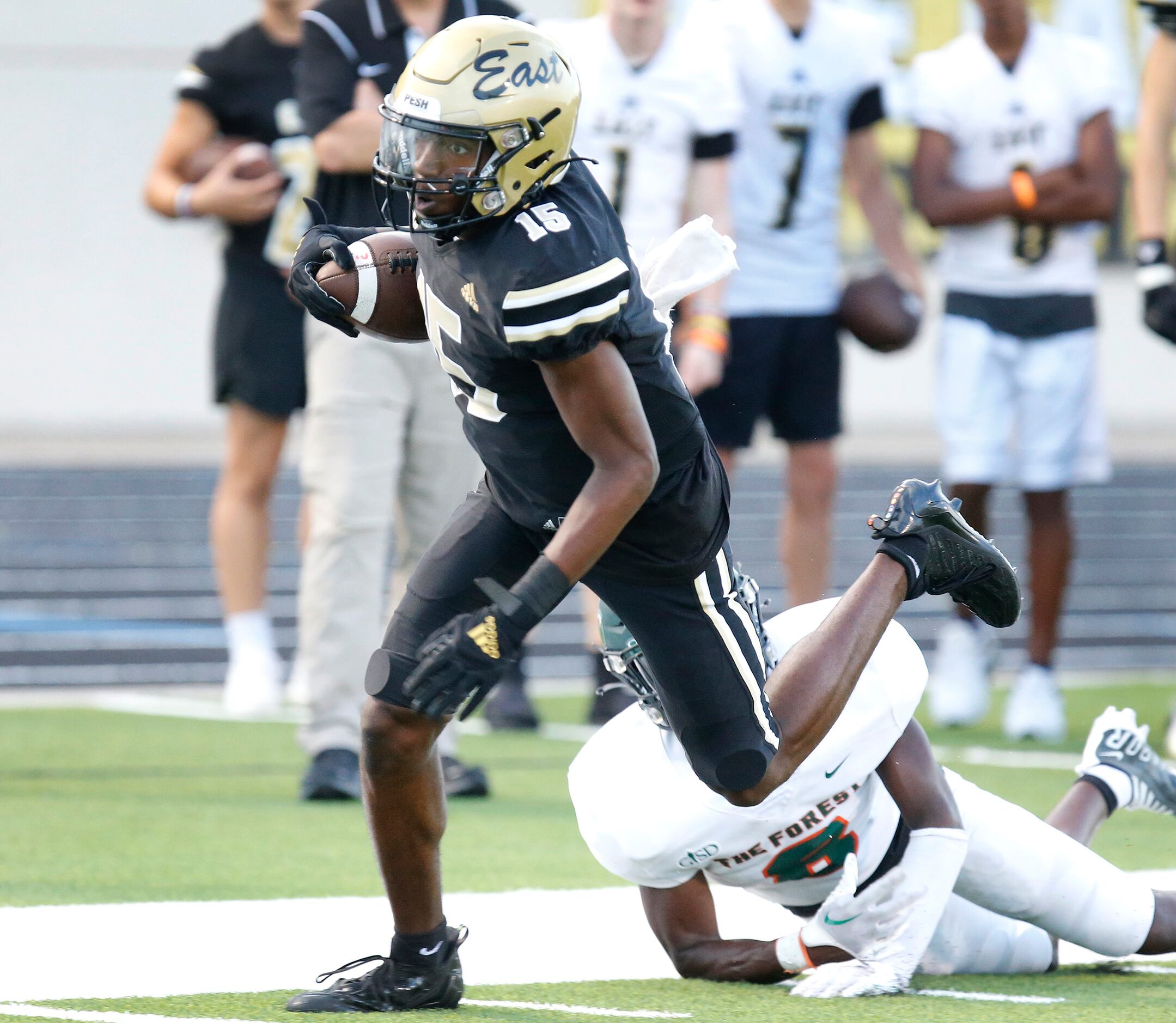 Plano East Senior High School wide receiver Elijah Prince (15) breaks the tackle attempt by...