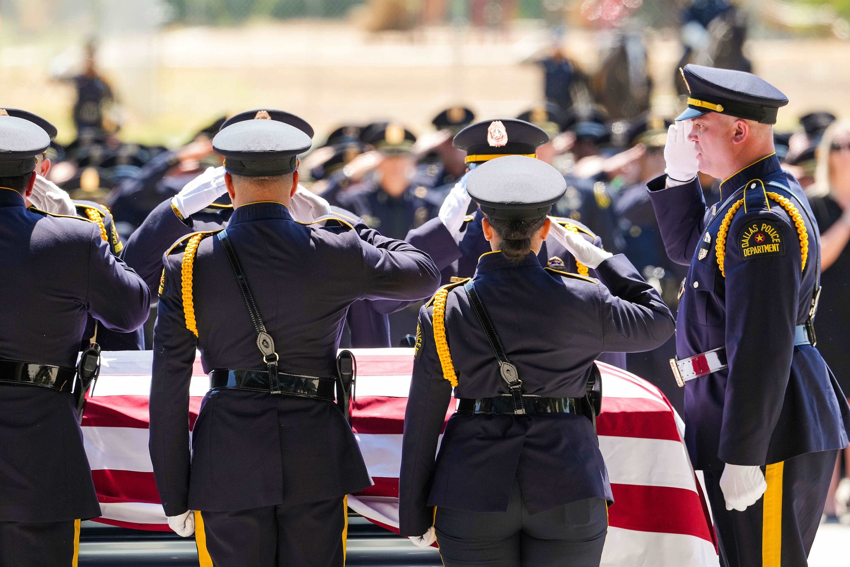 Members of the Dallas Police Honor Guard  salute the casket of officer Darron Burks during...