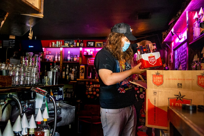 Manager Britt Clardy restocks supplies at Ten Bells Tavern in the Bishop Arts District of...