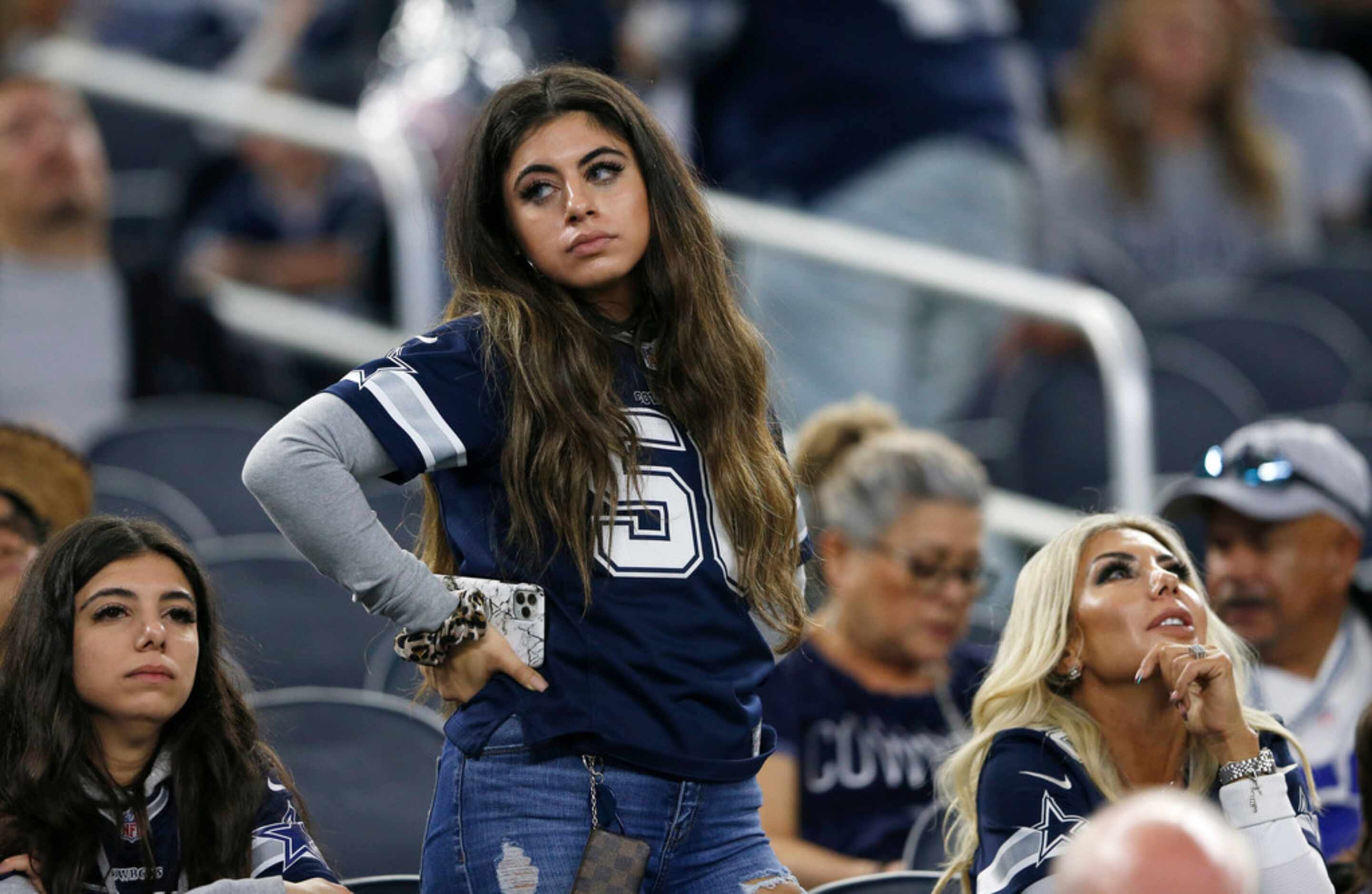 A Dallas Cowboys fan stands dejected late in the second half of play at AT&T Stadium in...