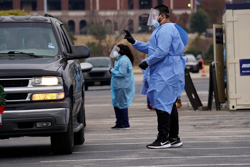 Curative Incorporated employees perform contact-free COVID-19 testing in the parking lot of...