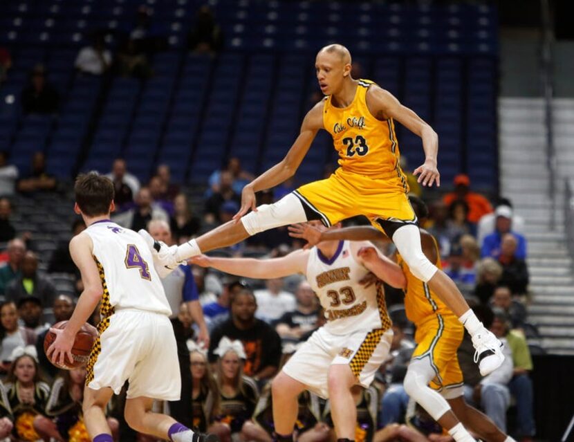 Oak Cliff Faith Academy's Jordan Walsh #23 goes high to prevent Liberty Hill's Carson...