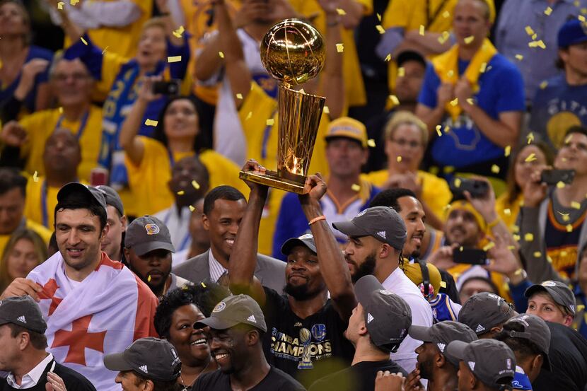 The Golden State Warriors' Kevin Durant holds the championship trophy after defeating the...