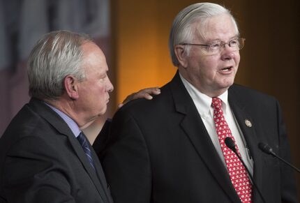 Rep. Joe Barton (right), R-Arlington, and coach of the Republican baseball team, holds a...