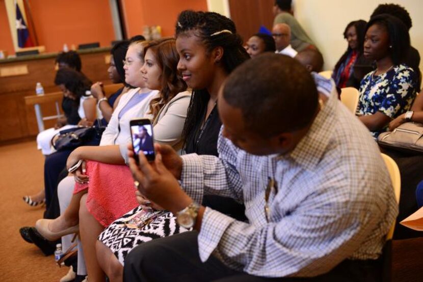 
Roy Williams takes a photo of his daughter Nyaira Harris, a member of the Mayor's Teen...