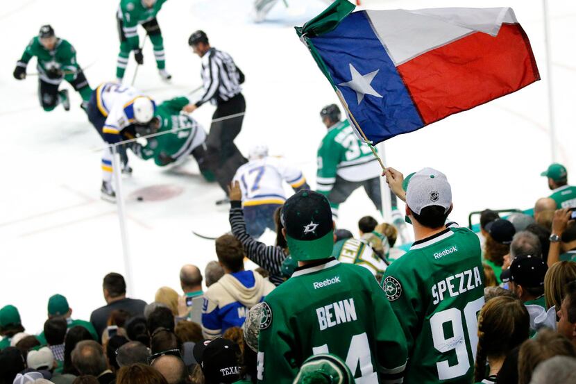 A Dallas Stars fan waves the Texas flag as the Stars and St. Louis Blues face off during the...