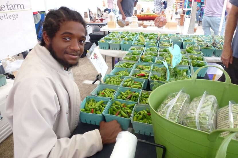 Paul Quinn College freshman Arthur McDade IV helps sell the harvest from the We Over Me Farm...
