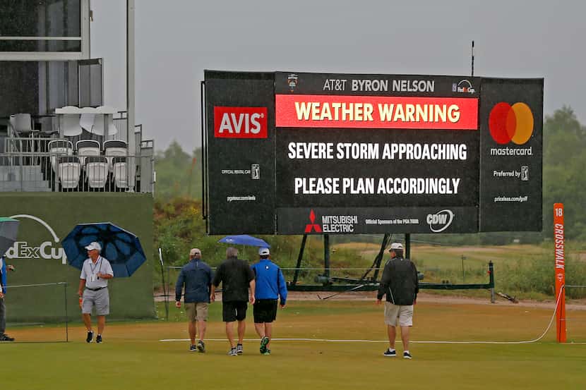 Fans crossed the 18th fairway during a weather delay of the final round of AT&T Byron Nelson...