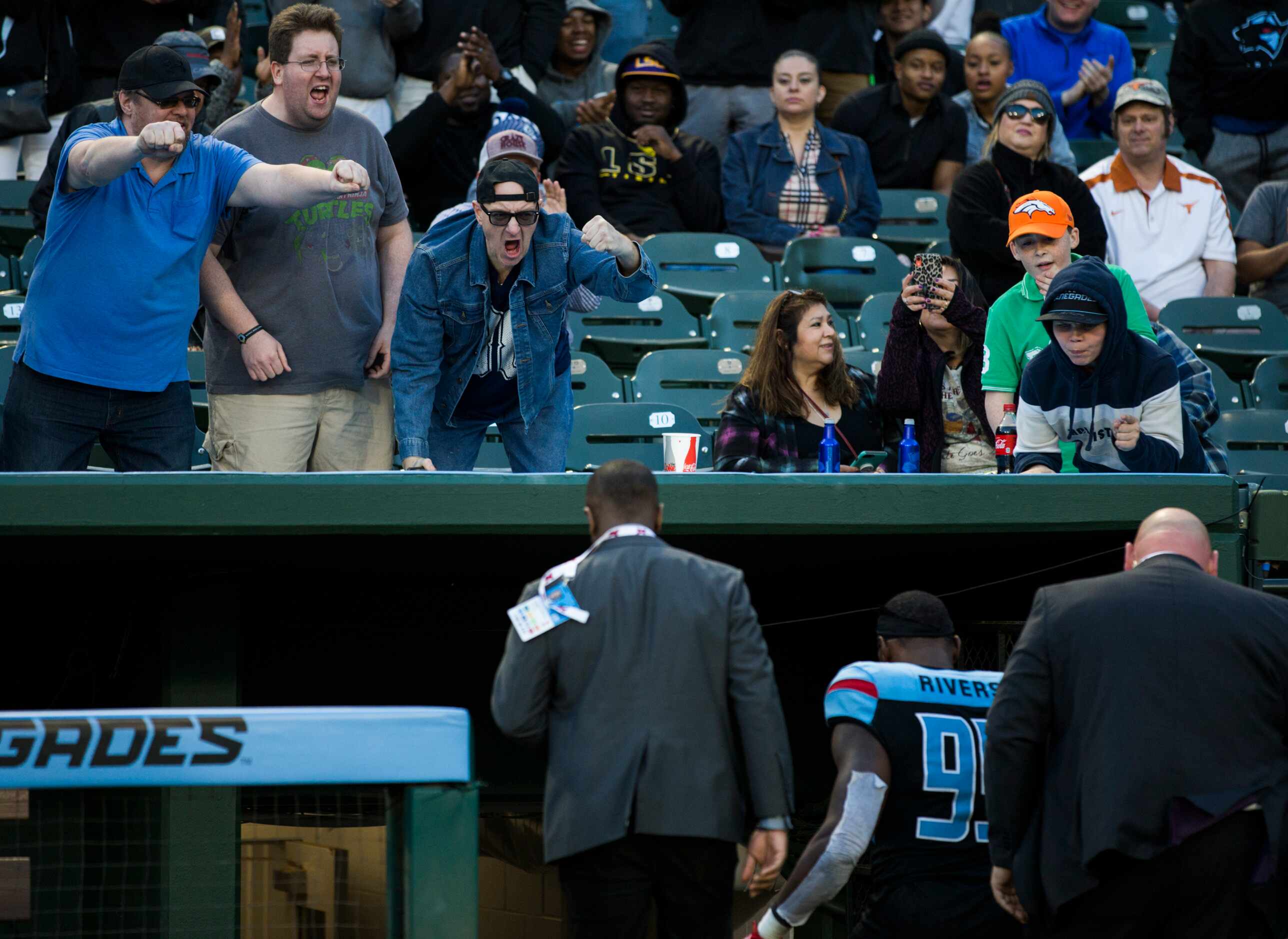 Fans cheer on Dallas Renegades defensive end Gerald Rivers (99) as he is escorted off the...