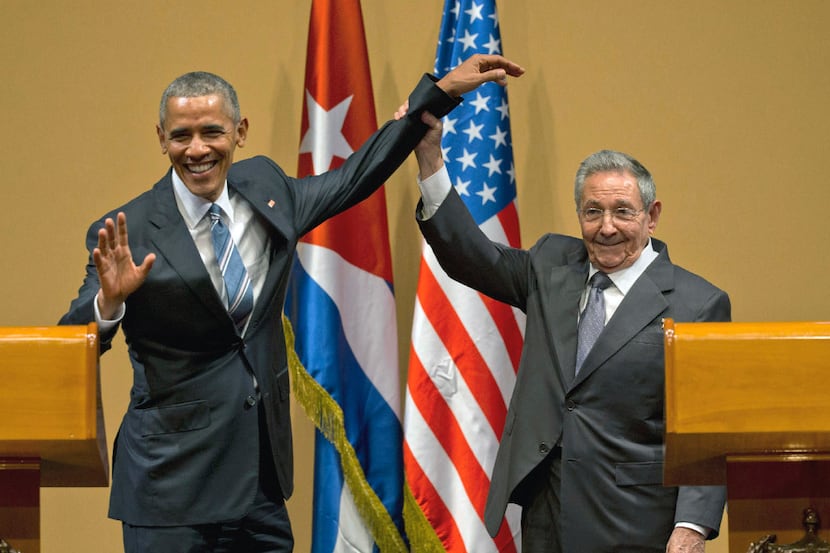 FILE - In this March 21, 2016 file photo, Cuban President Raul Castro, right, lifts up the...