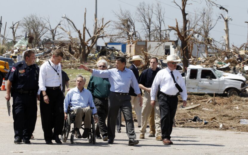 Then-Gov. Rick Perry, center, and then-Attorney General Greg Abbott -- shown inspecting...