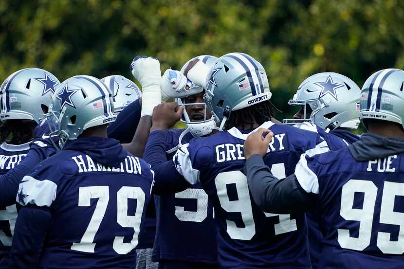 Dallas Cowboys defensive end Randy Gregory (94) huddles with fellow defensive linemen, from...
