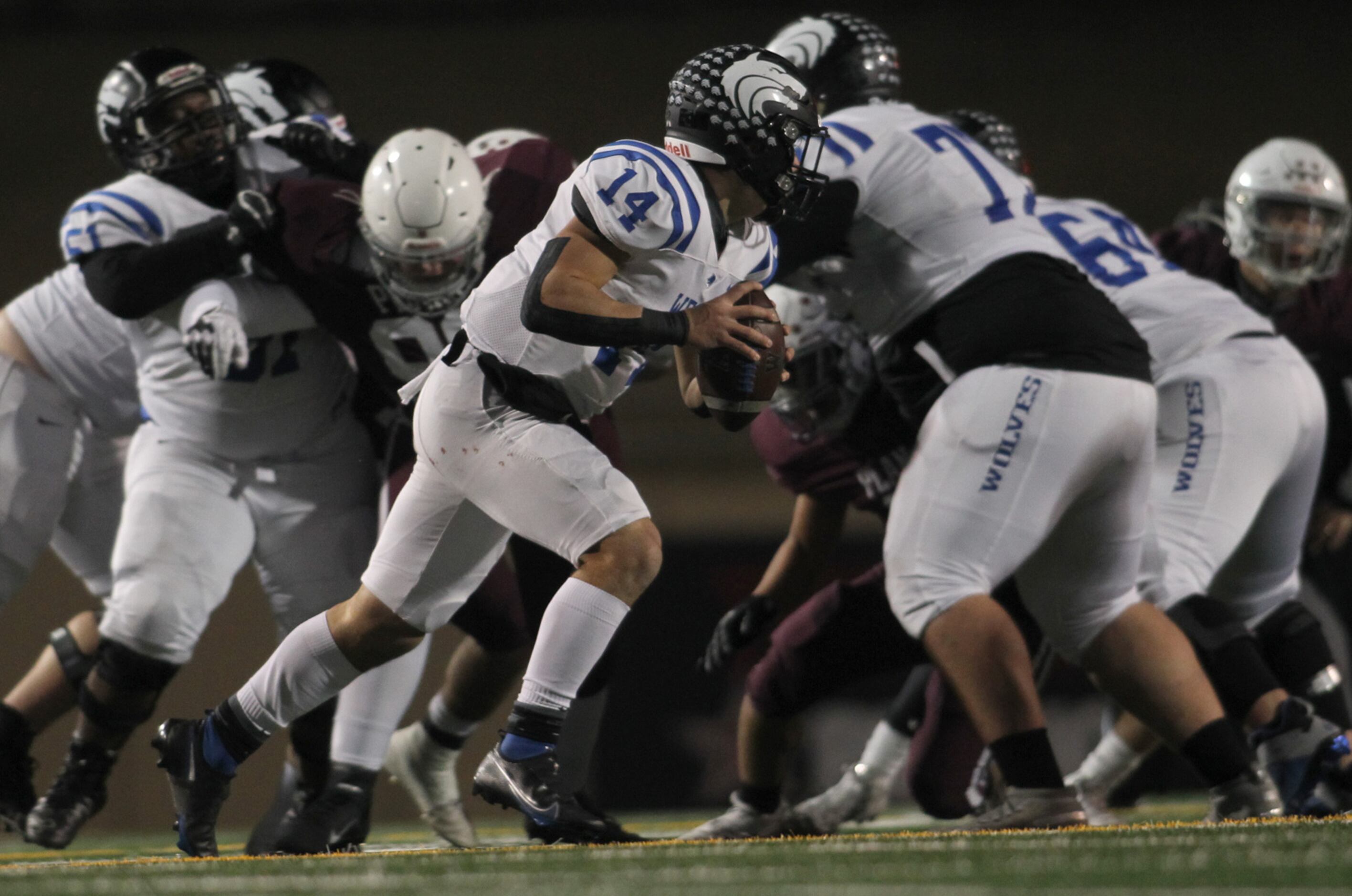 Plano West quarterback Vance Feuerbacher (14) opts to roll out of the chaos on a quarterback...