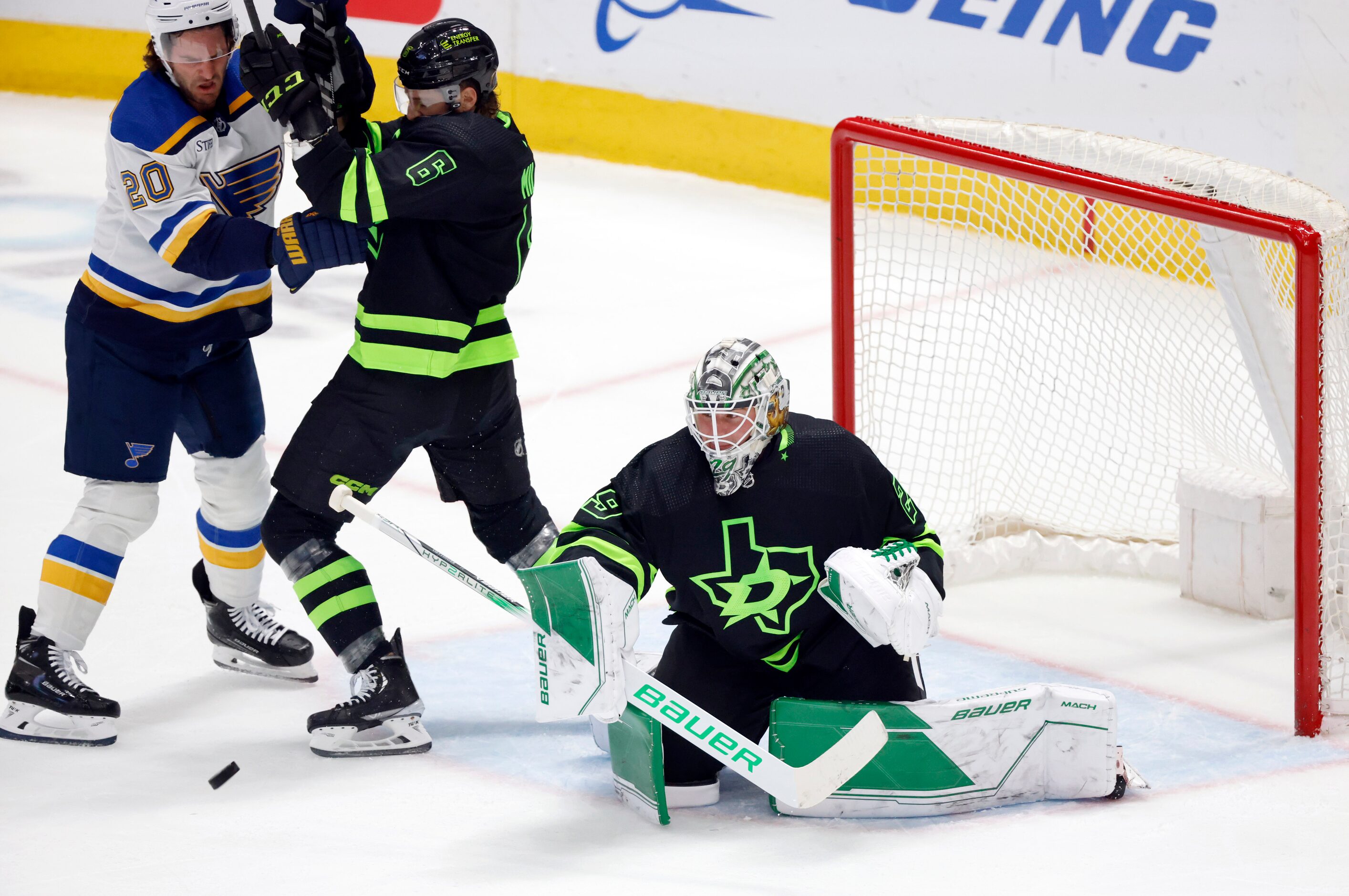 Dallas Stars goaltender Jake Oettinger (29) deflects the puck as Stars defenseman Colin...