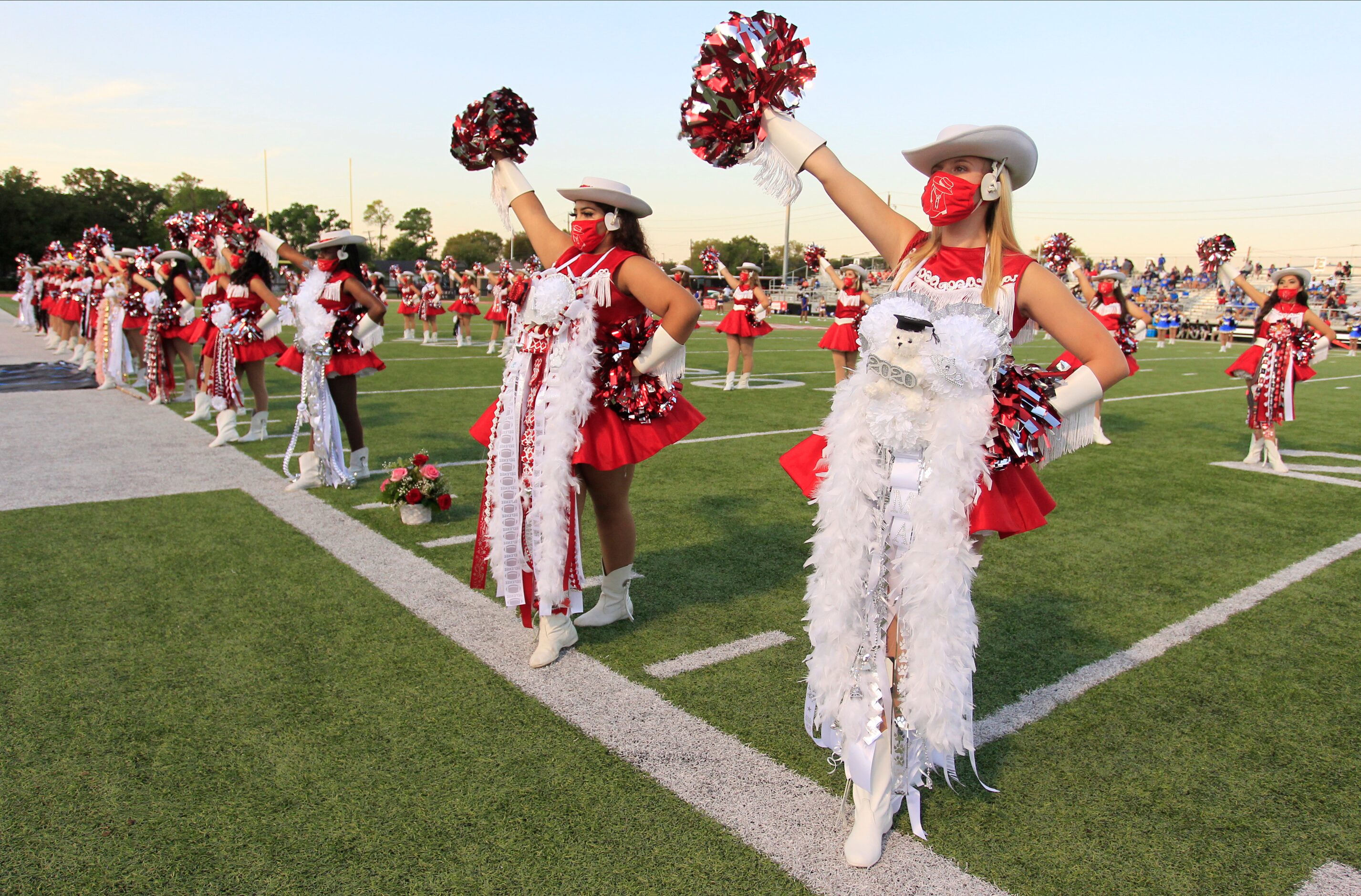 The Terrell Tigerettes perform in masks before the first half of a high school football game...