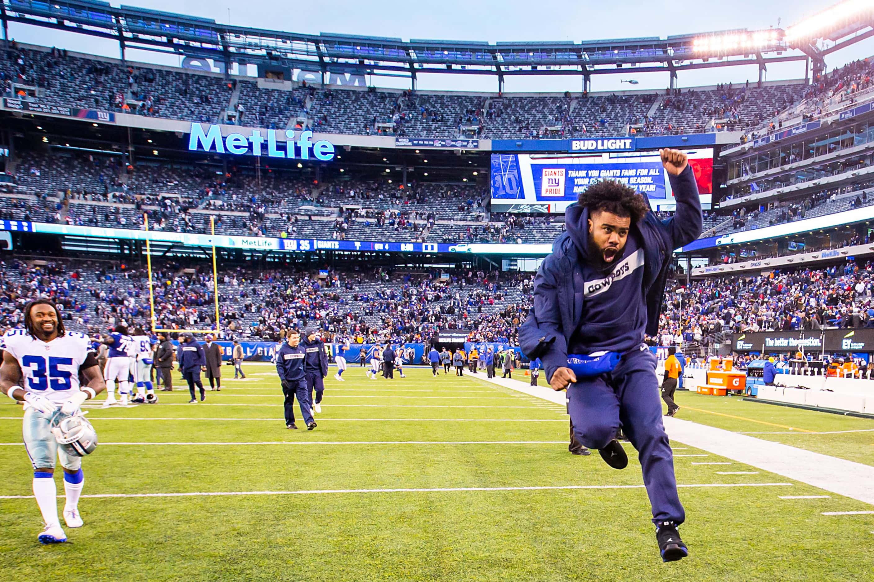 Dallas Cowboys running back Ezekiel Elliott, who was inactive for the game, celebrates as he...