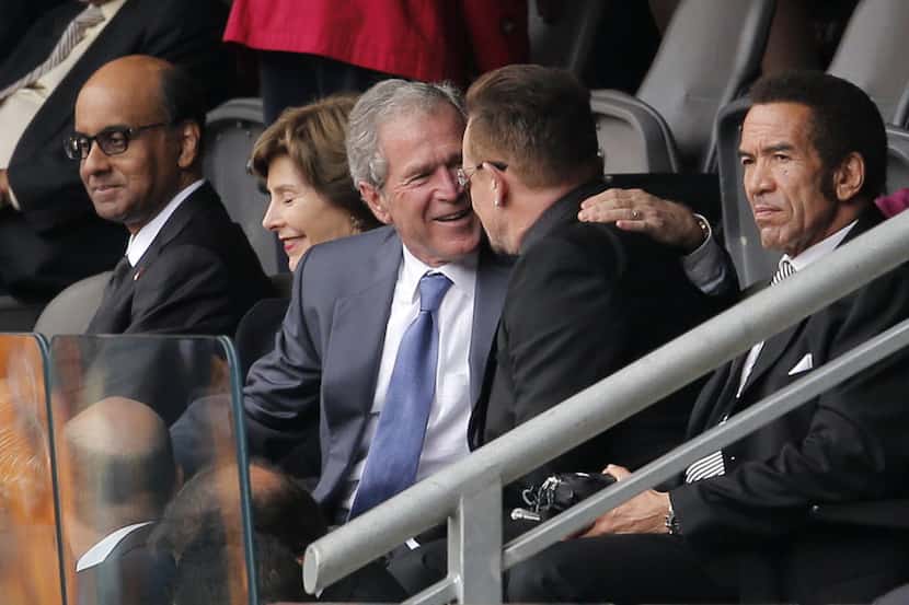 Former U.S. President George W. Bush, left, embraces Irish rock star Bono during the...
