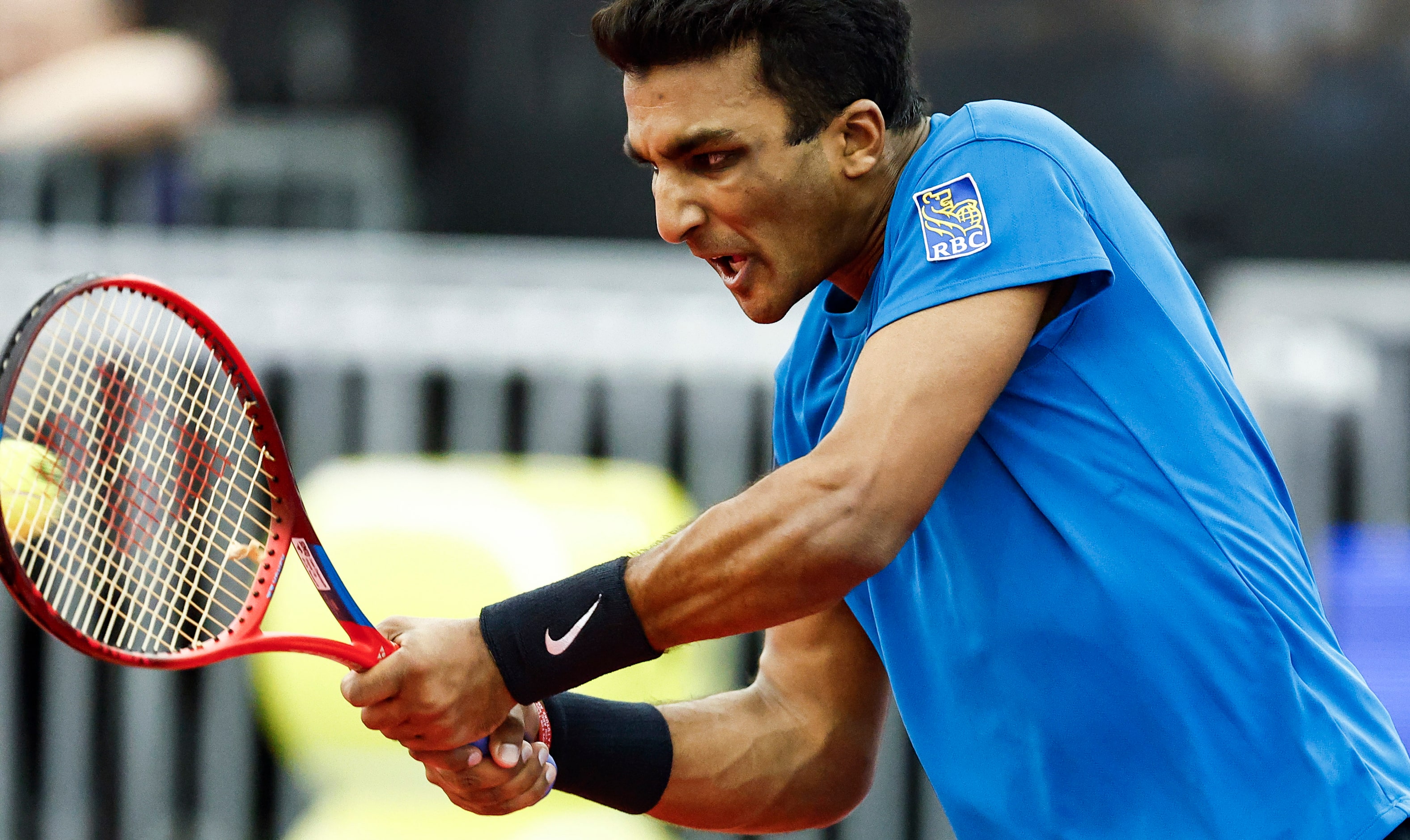 SMU senior Caleb Chakravarthi returns the ball in a match against Vasek Pospisil during the...