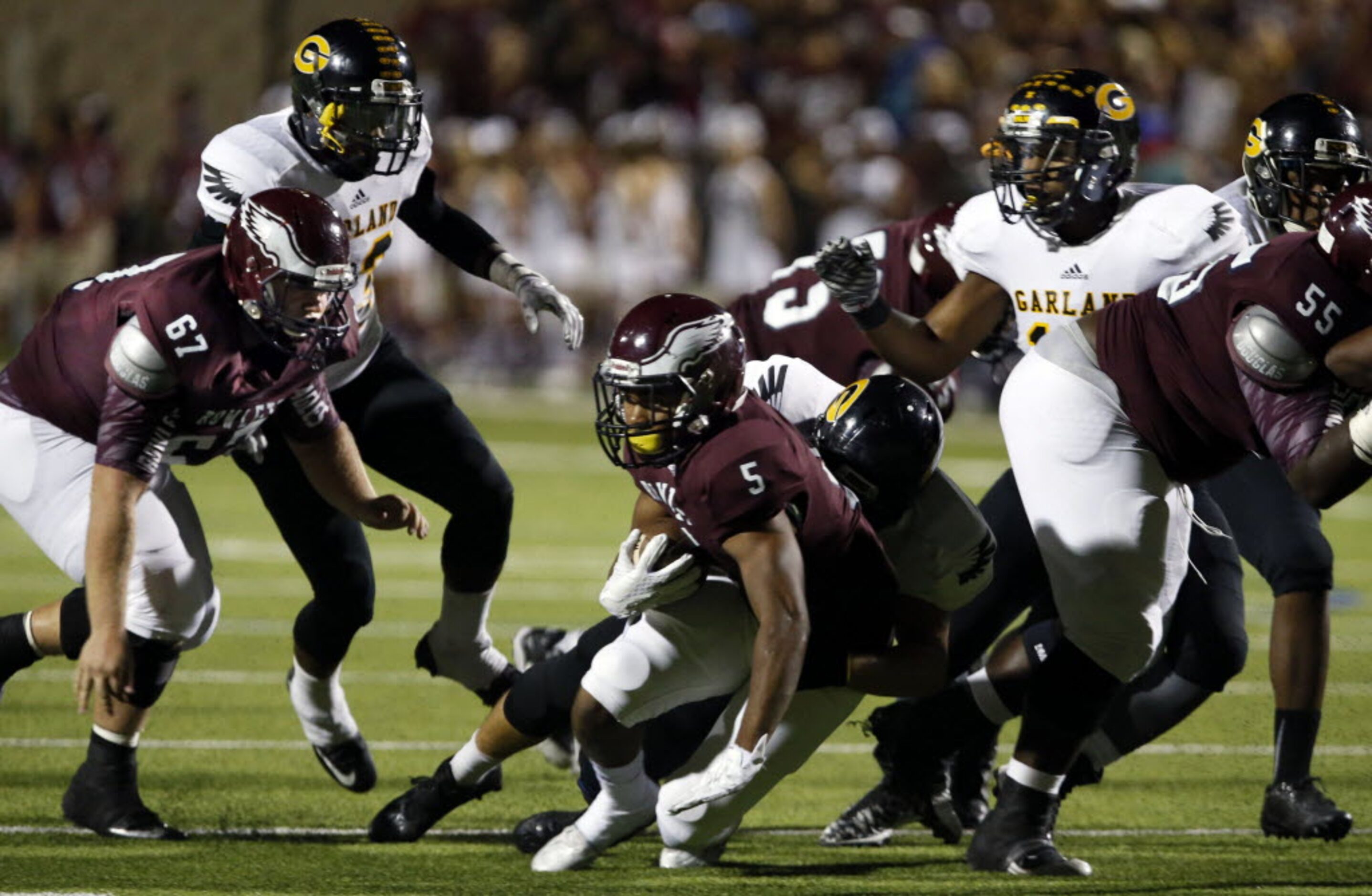 (TXHSFB) Rowlett RB Kobe Morrow (5) gets a first down in a melee of players during the first...