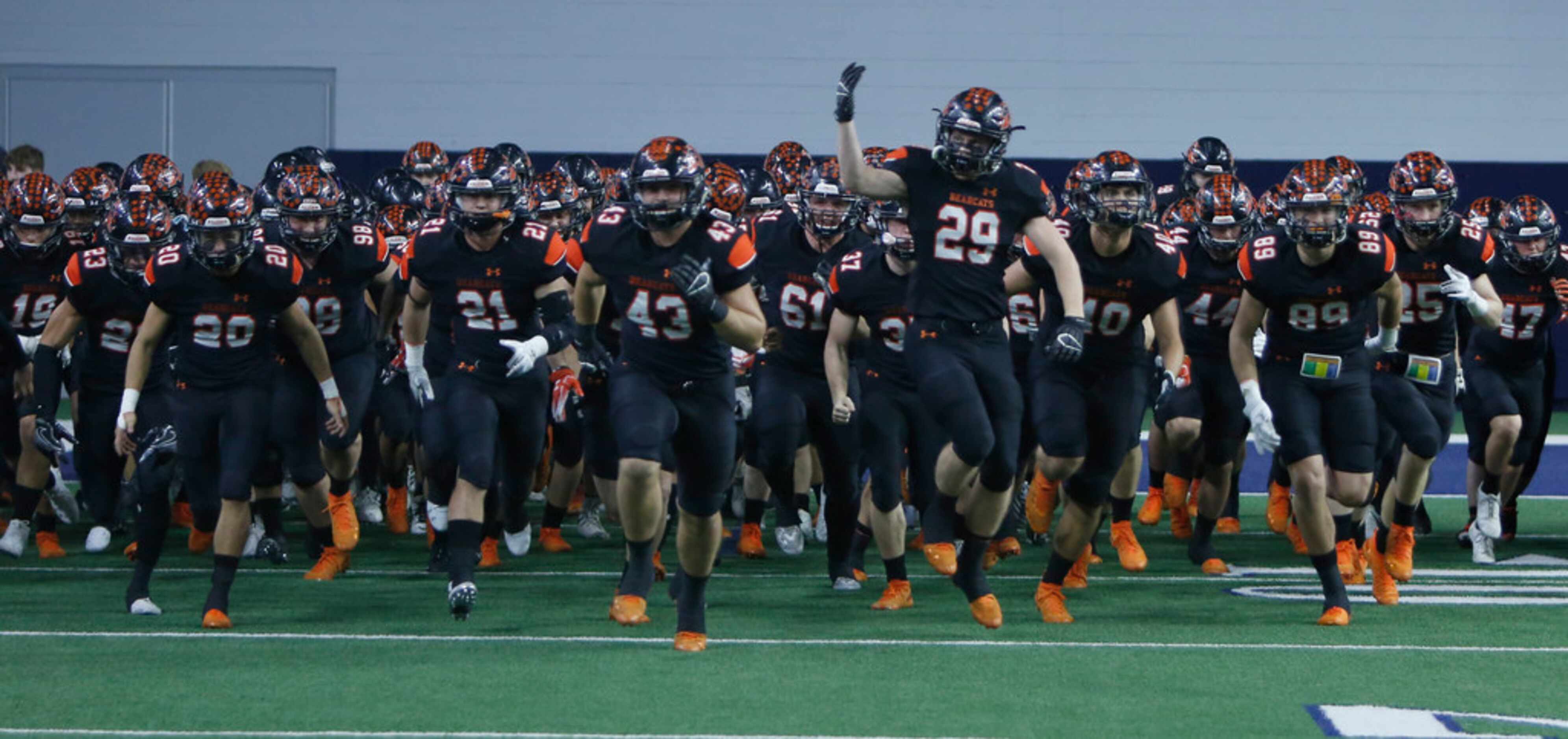 Aledo Bearcats players storm the field just prior to the opening kickoff of their game...