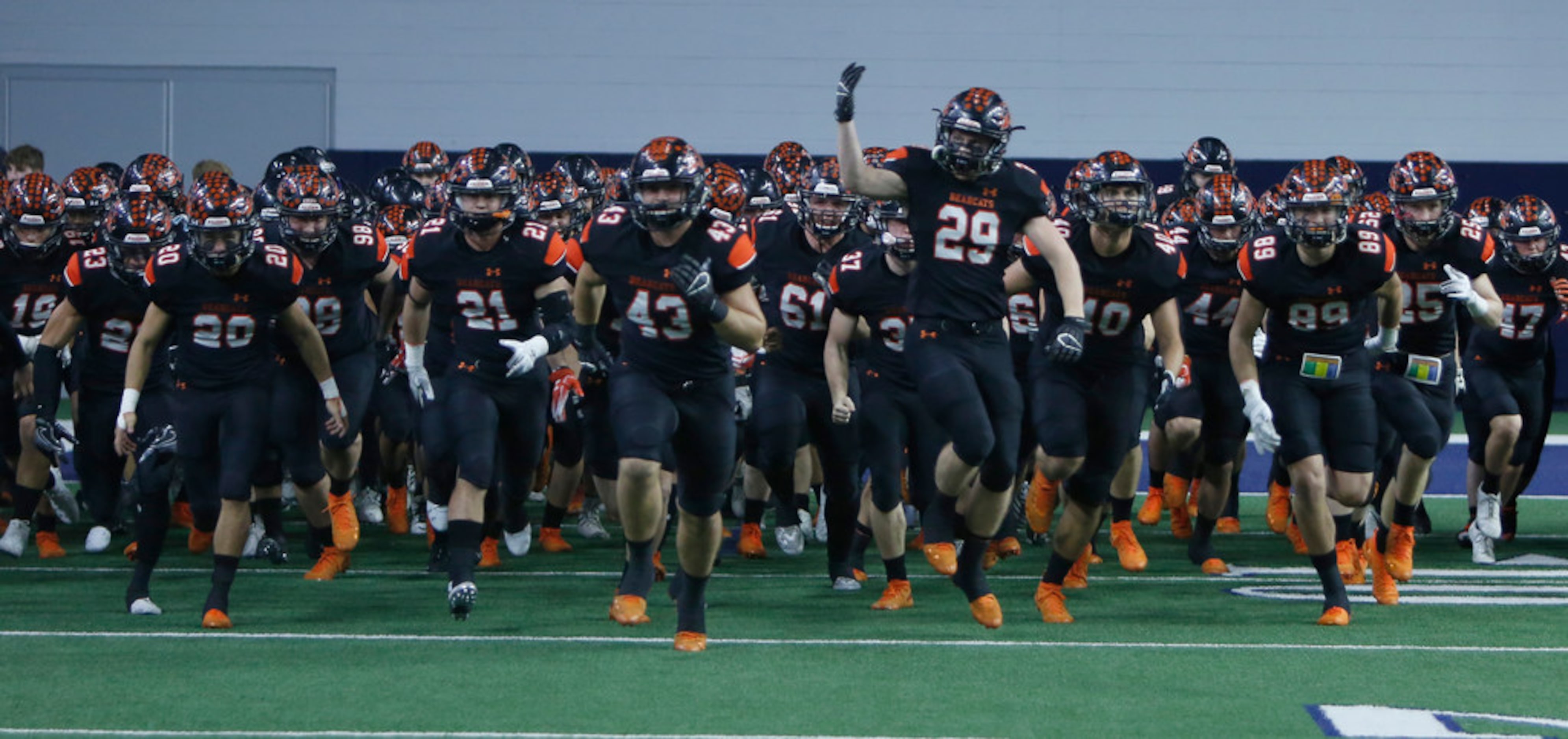 Aledo Bearcats players storm the field just prior to the opening kickoff of their game...