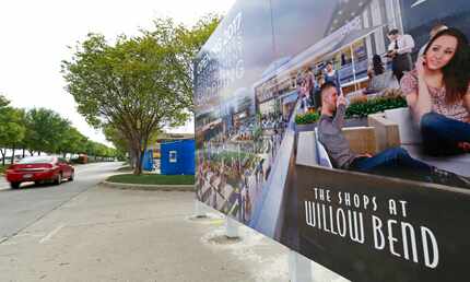 A car passes by a rendering sign at the renovation project site of The Shops at Willow Bend...