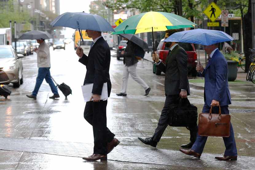 Pedestrians walk across Main Street during a rain shower in downtown Dallas in March.