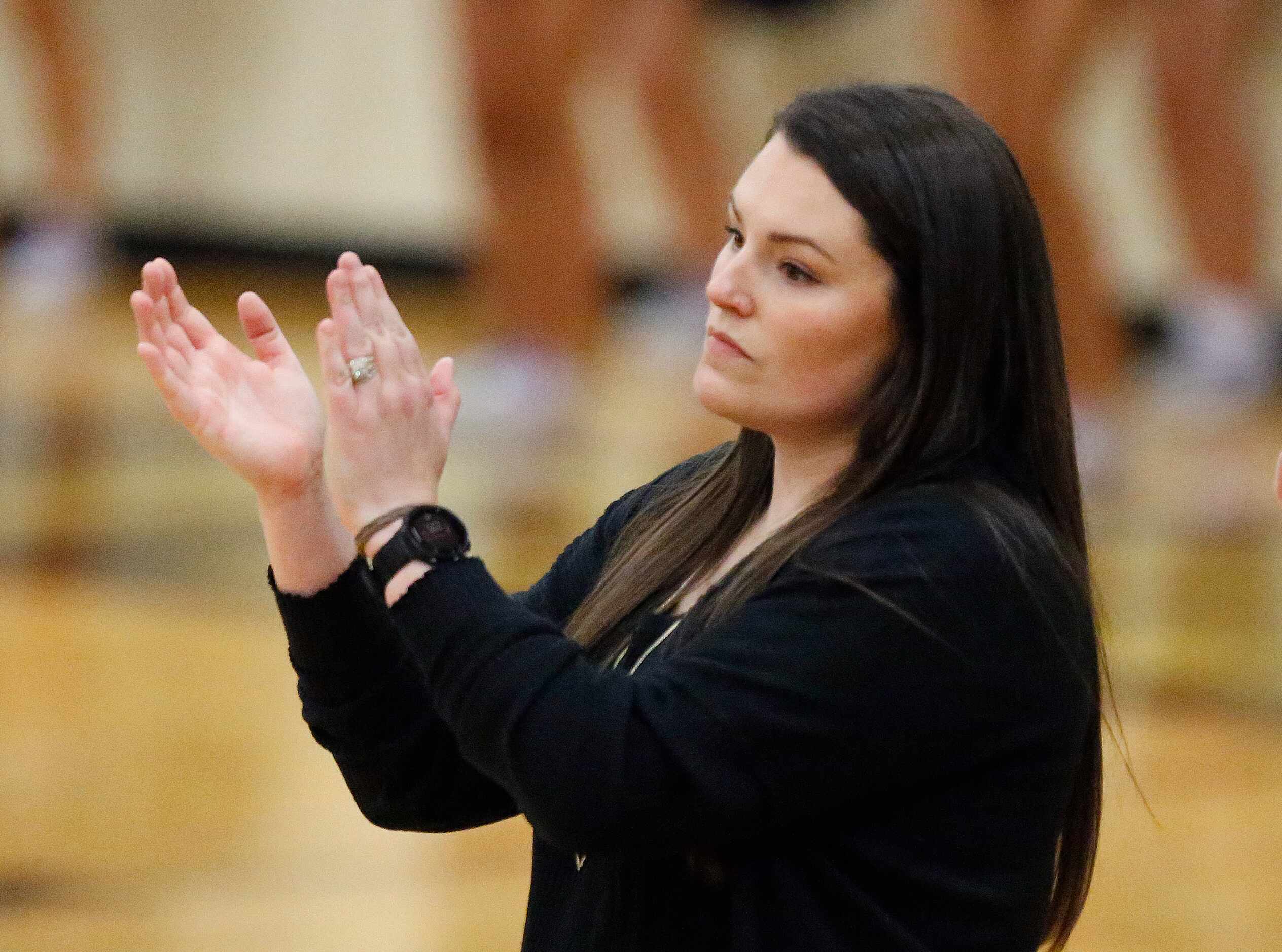 Prosper High School head coach Erin Kauffman applauds her teams effort during game two of...