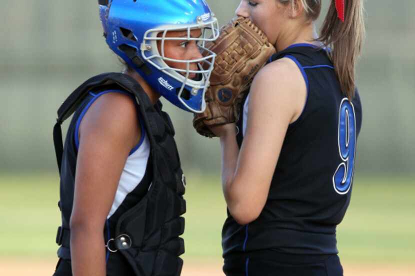 Hebron's pitcher Heather Stearns (9 - right) confirs with catcher Jasmine Parker (3 - left)...