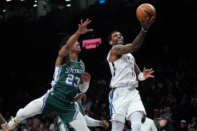 Brooklyn Nets' Kyrie Irving, right, drives past Detroit Pistons' Jaden Ivey during the first...