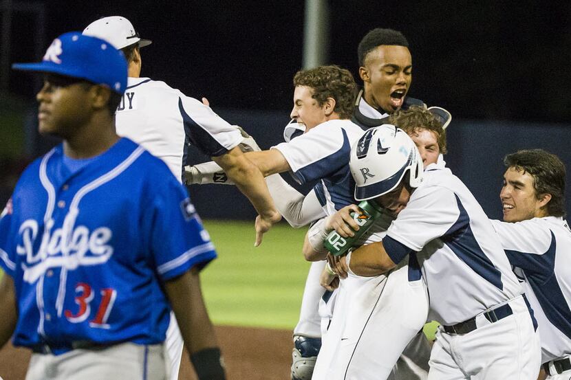 Teammates mob Jesuit infielder J.T. Mix (center)  after he drew a bases loaded walk to force...