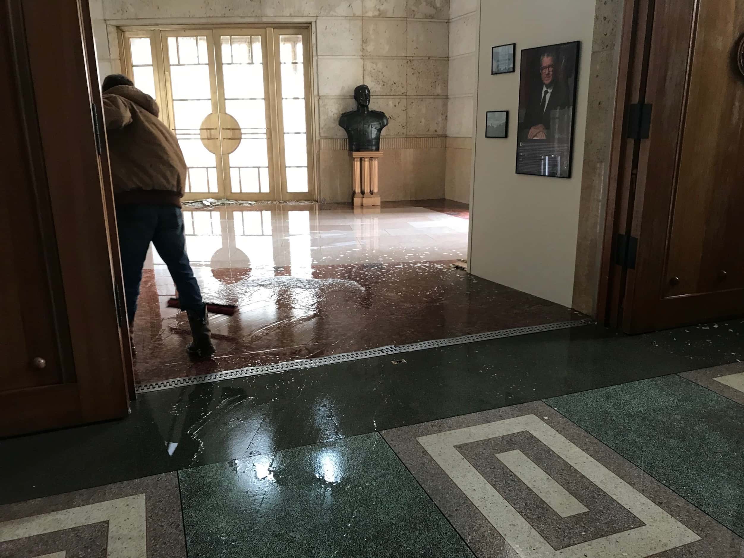A photo shows water being swept out of the Hall of State in Dallas on Feb. 17, 2021. The...