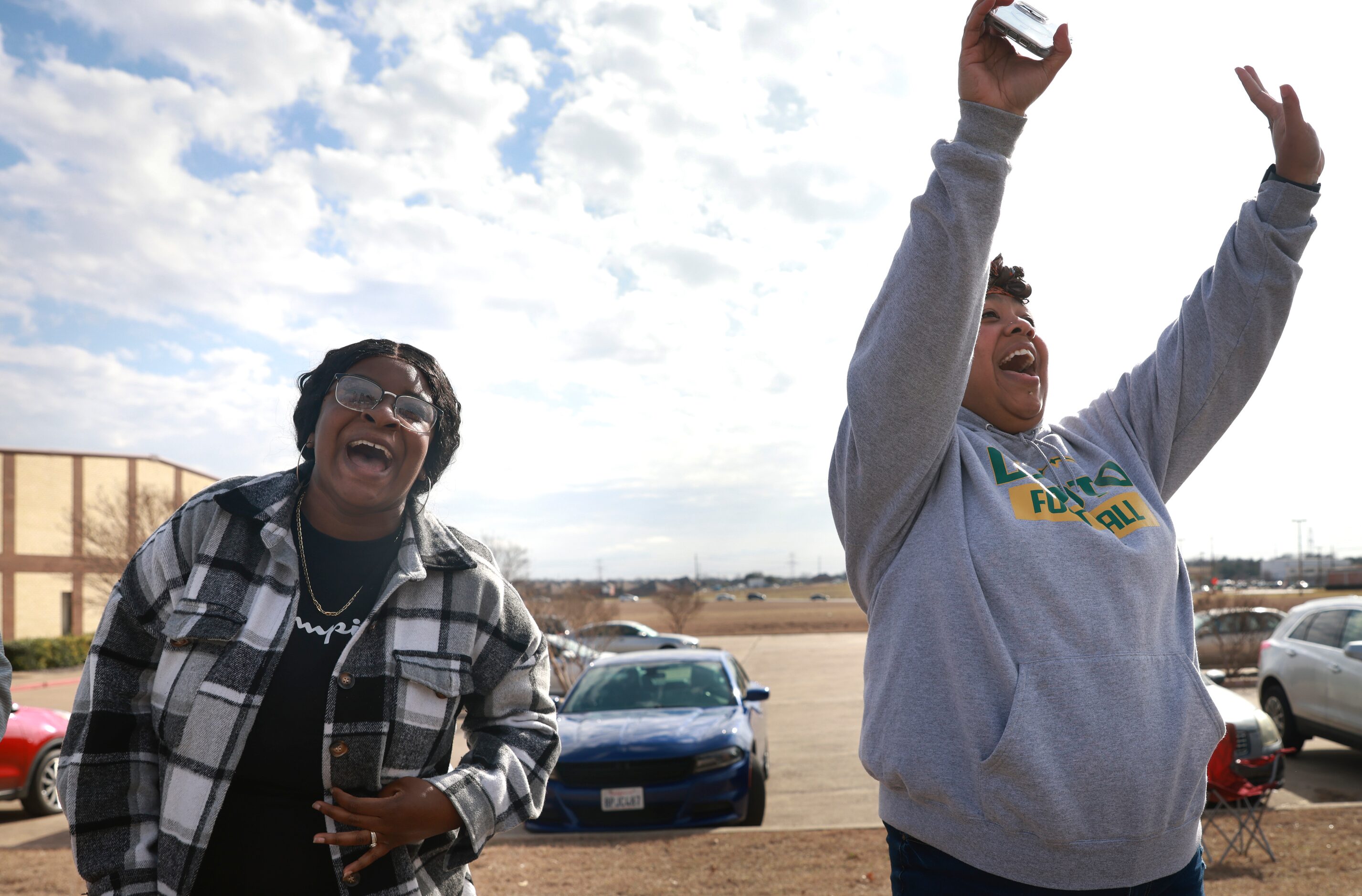 Kimberly Gilbeaux and Michelle Mercado scream and wave to the DeSoto High School football...