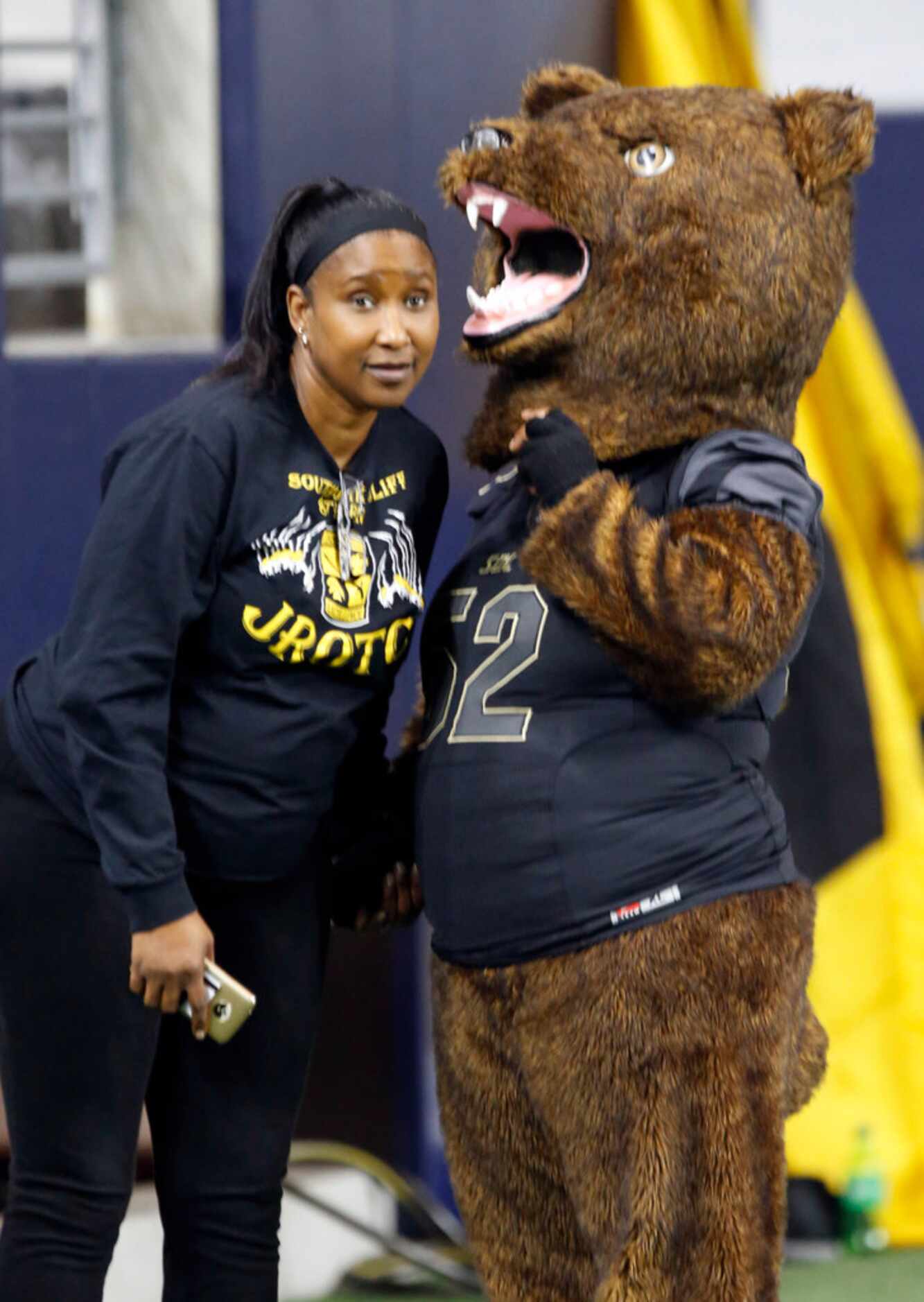 A handler patiently listens to the South Oak Cliff Golden Bears mascot during the first half...
