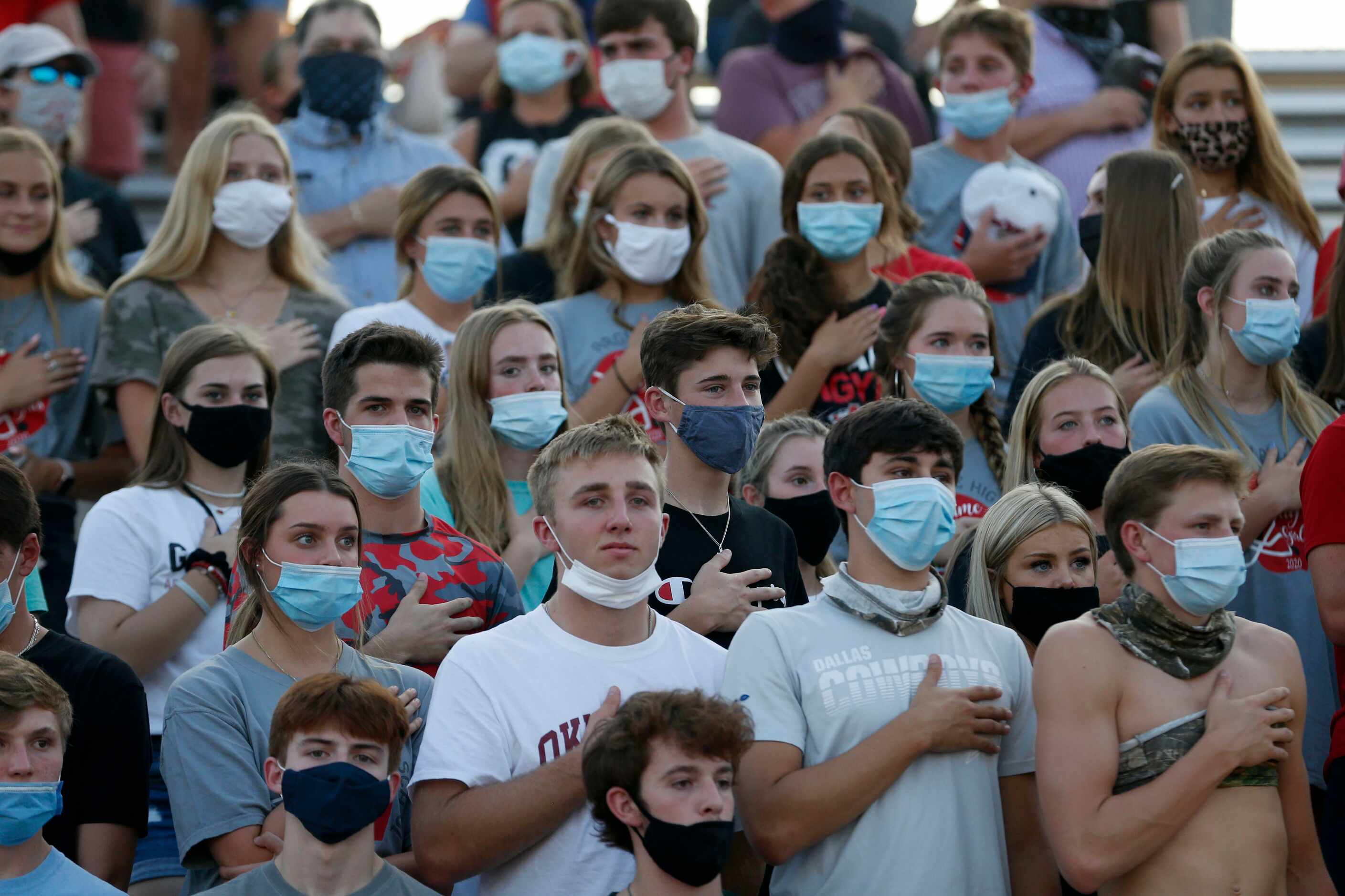 Fans in the Argyle student section in face coverings stand during the national anthem before...
