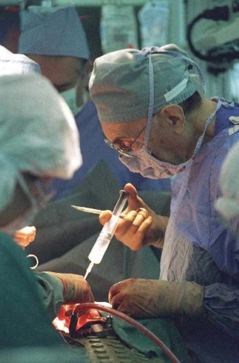  Dr. Michael DeBakey assists in a quadruple bypass operation in 1998, shortly before his...