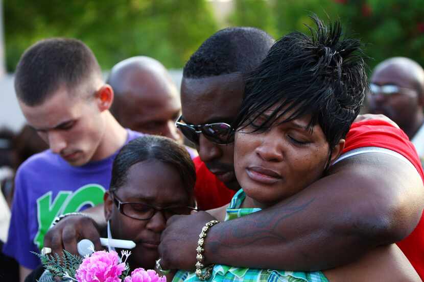 April Richardson (right) in an embrace with family members Billie Washington and Everett...