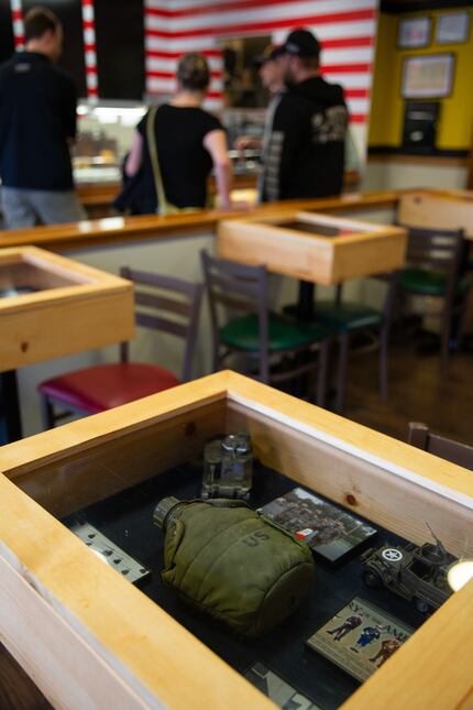 The tables serve as shadowboxes, showcasing military artifacts and memorabilia.