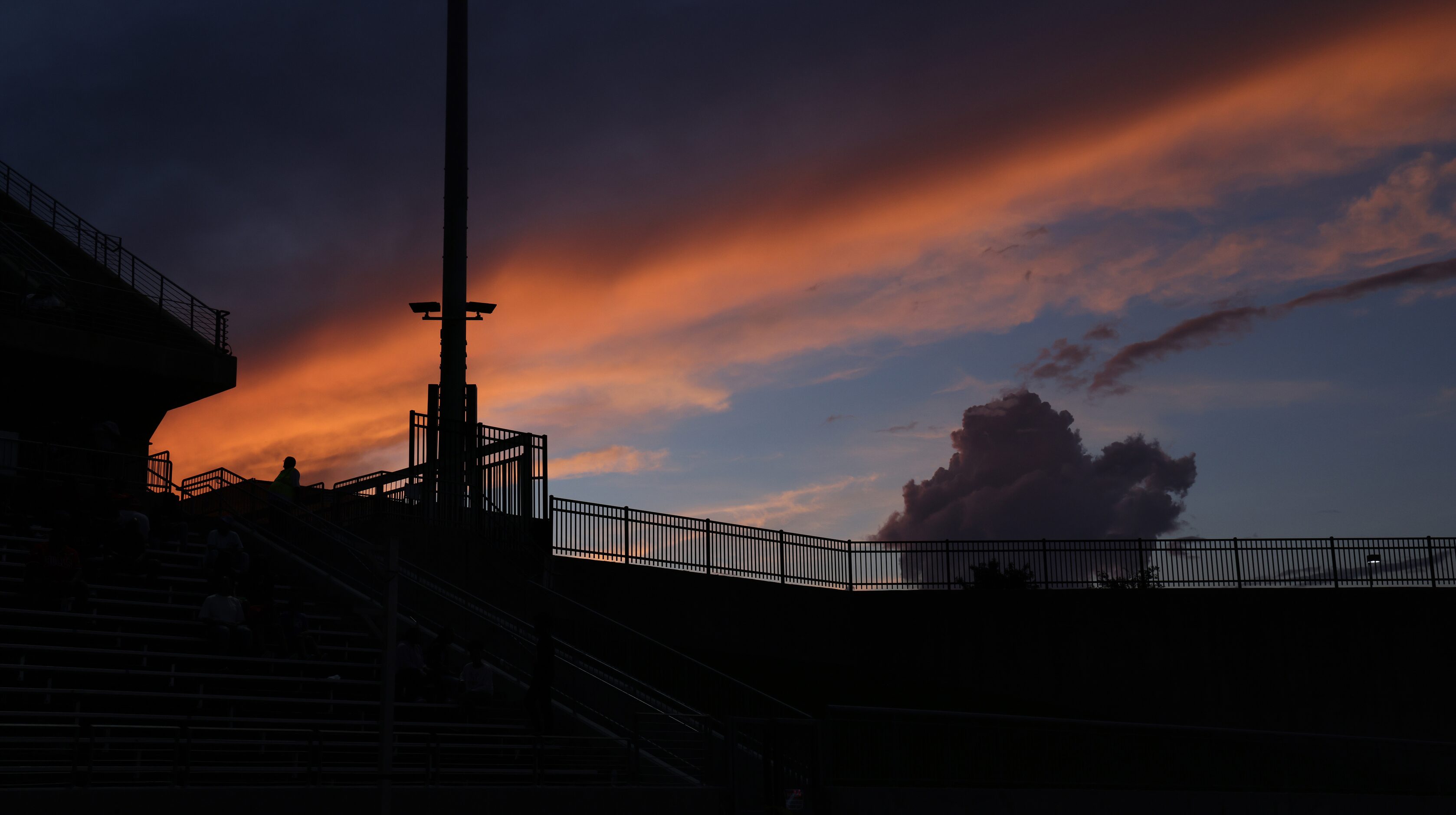 A lone member of the security team stands at his post in front of the setting sun during the...