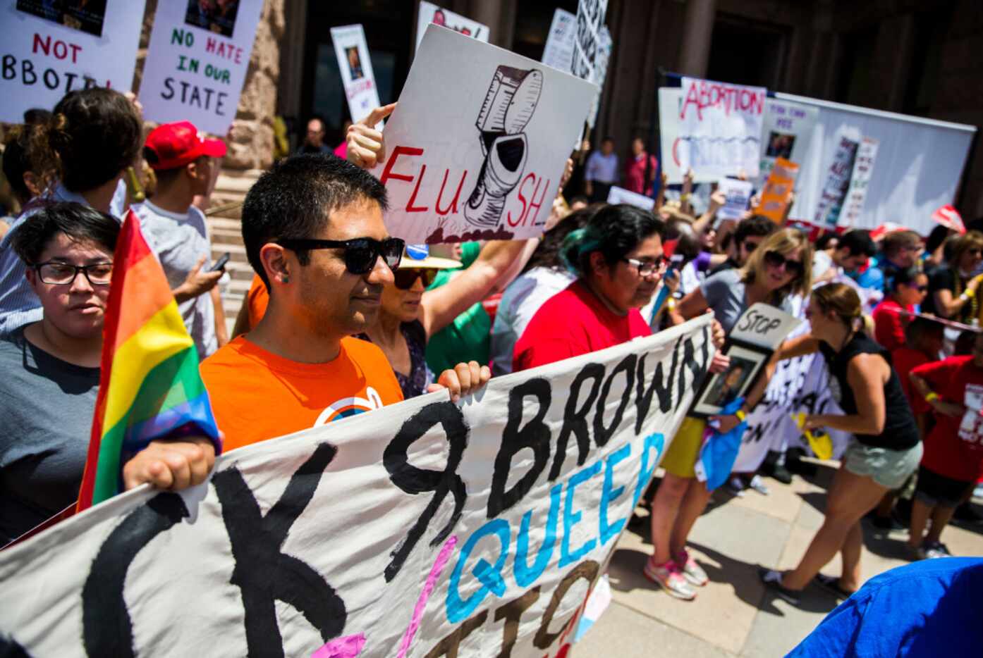 Alfonso Mendoza, left, of El Paso and other protesters held signs during a One Texas...