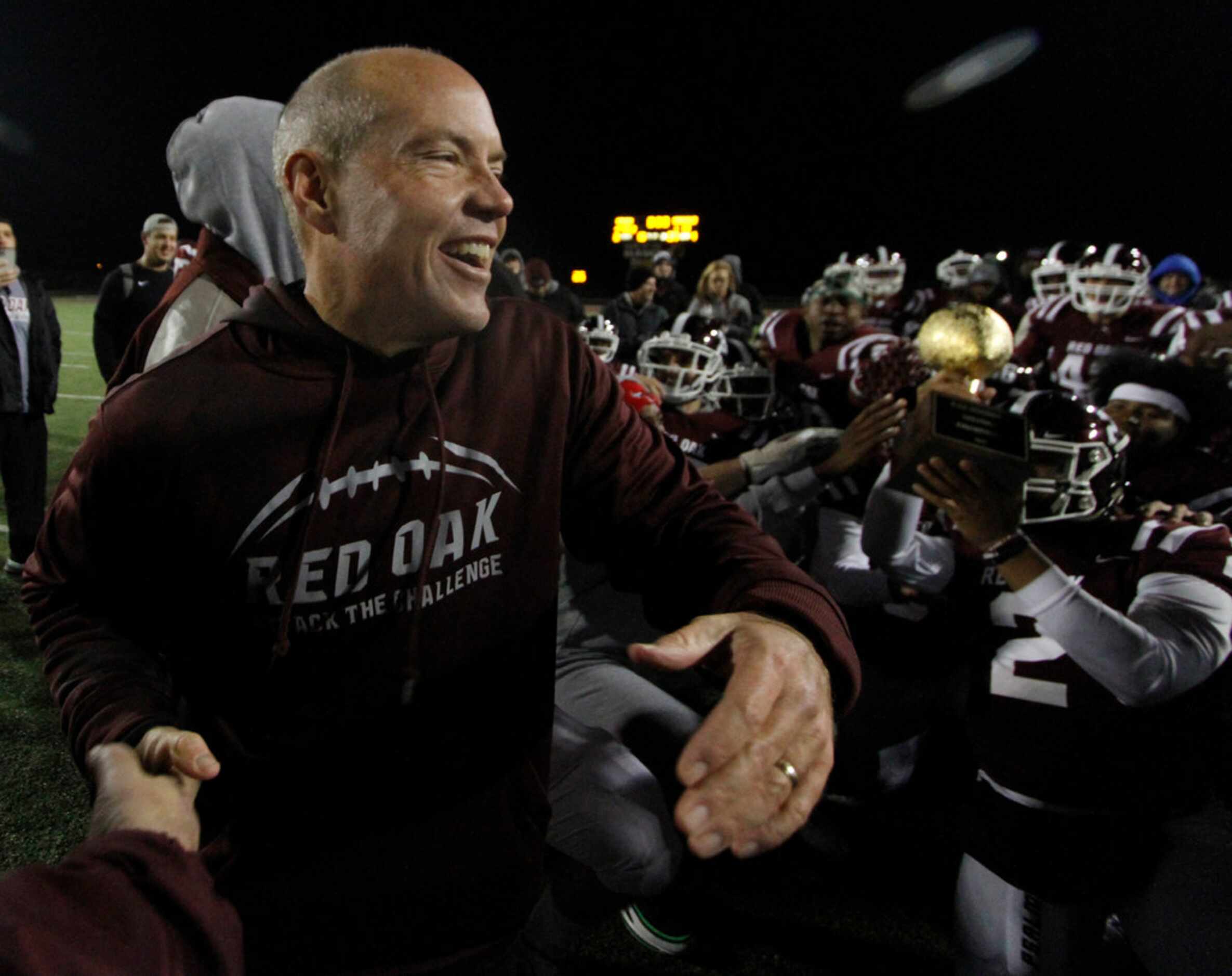 Red Oak head coach Chris Ross was all smiles as he celebrates with his players at midfield...