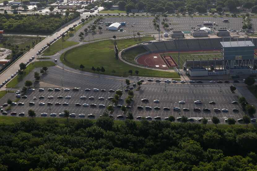Hundreds of cars weave around the Ellis Davis Field House at a COVID-19 test site on Friday,...