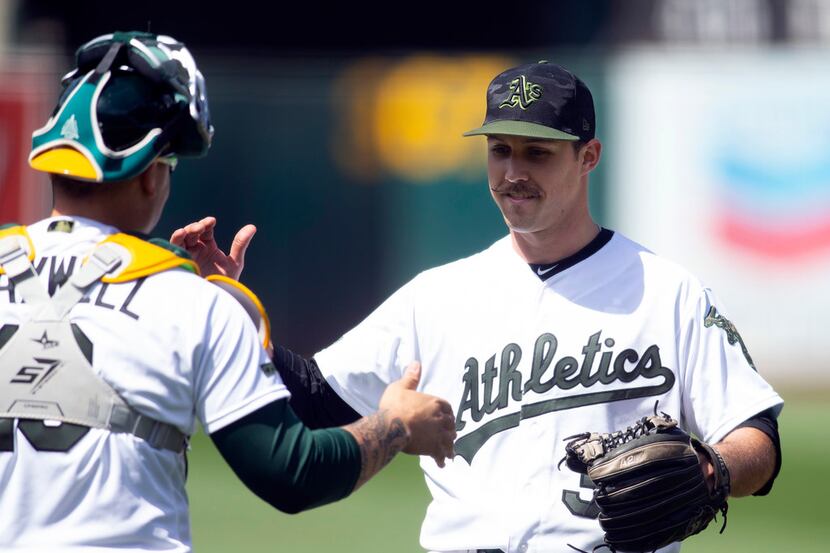 Oakland Athletics pitcher Daniel Mengden, right, celebrates his two-hit shutout victory over...