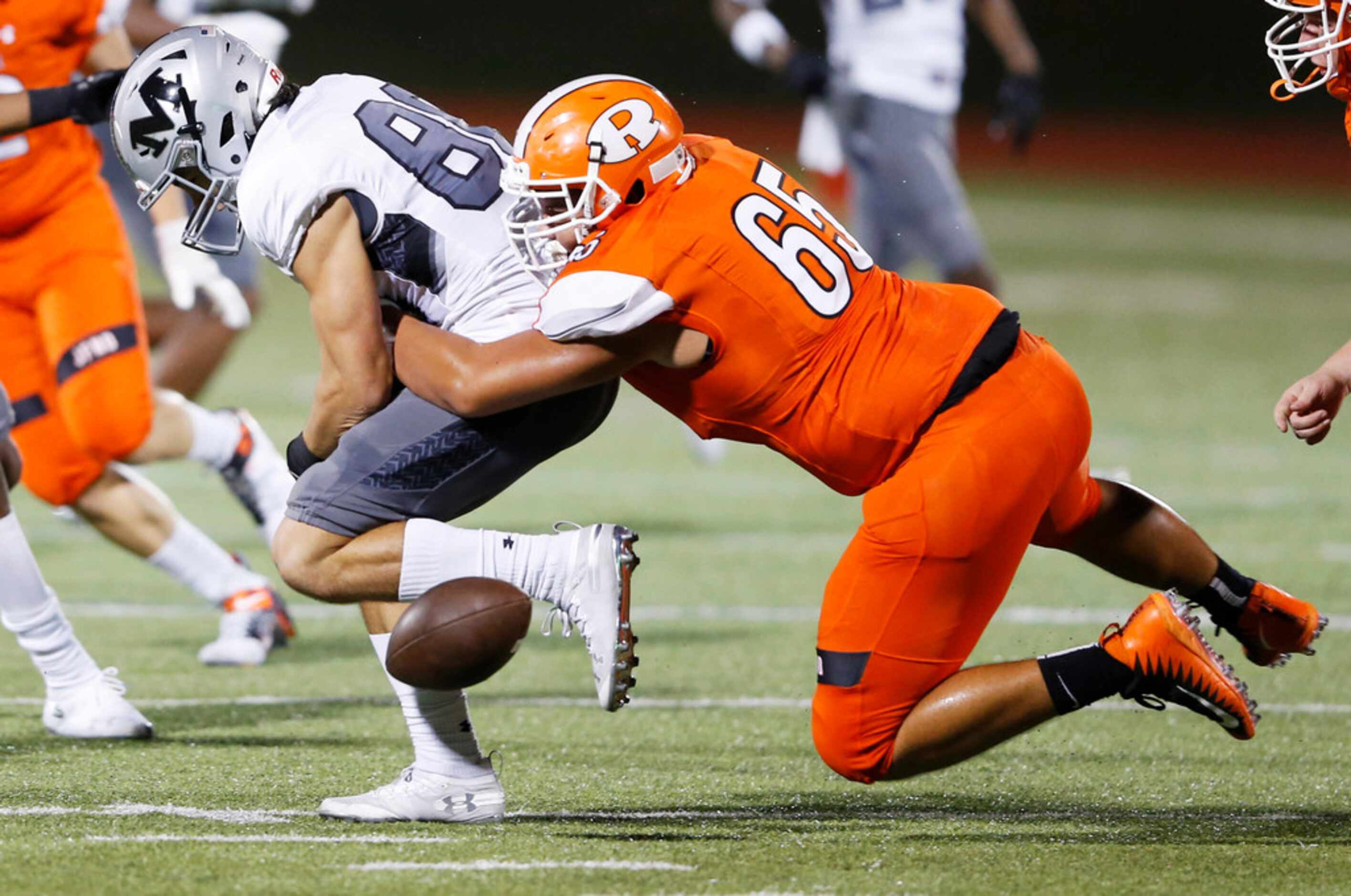 Rockwall's Landon Gibson (65) knocks the ball out of the hands of Arlington Martin's...